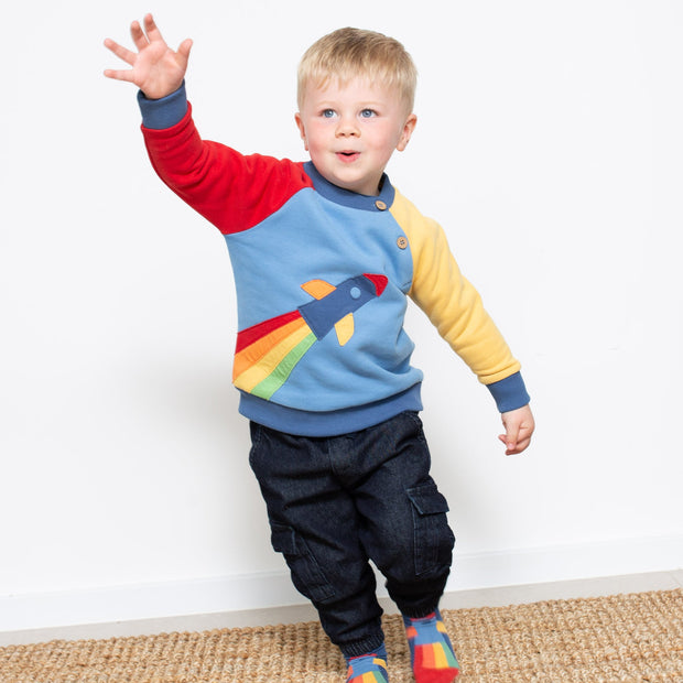 Boy in rainbow rocket sweatshirt